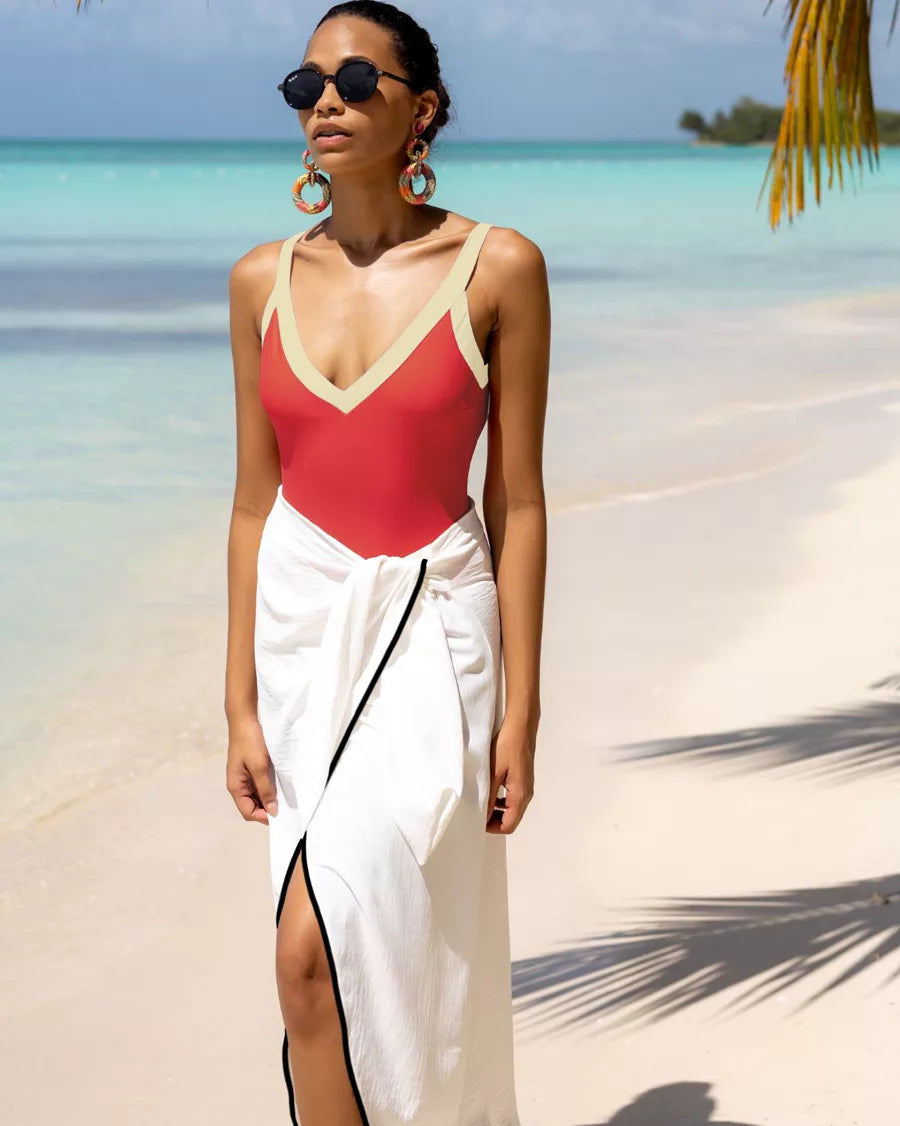 Falda pareo blanca con vivos negros sobre bañador rojo en la playa